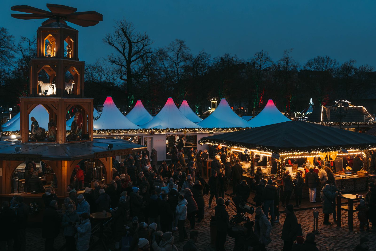 Beleuchteter Weihnachtsmarkt am Abend – Symbolfoto
